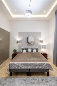 1 dormitorio con 1 cama grande y espejo en Central Market Residence, en Budapest