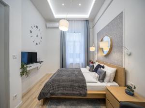ブダペストにあるCentral Market Residenceのベッドルーム1室(ベッド1台、壁掛け時計付)