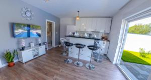 a living room with a kitchen with a counter and stools at Sweet Retreat on Buna Riverside - with private pool in Blagaj