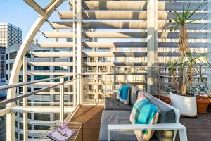 un balcone con divano e sedie in un edificio di Luxury Loft in the CBD with Outdoor Living a Sydney