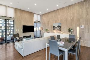 uma sala de estar com um sofá branco e uma mesa em Luxury Loft in the CBD with Outdoor Living em Sidney