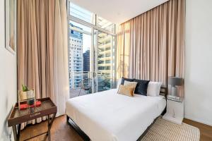 a bedroom with a large bed and a large window at Luxury Loft in the CBD with Outdoor Living in Sydney
