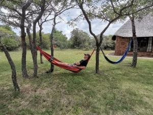 un hombre tendido en una hamaca en un campo en Moletani Game Ranch, en Kareefontein 127 fotos más