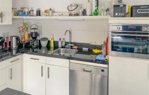 a kitchen with a sink and a counter top at Cozy Home In Eext With Kitchen in Eext +18 photos