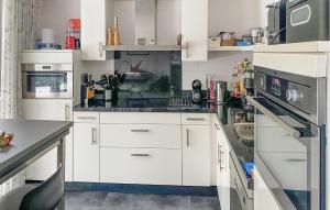 una cocina blanca con armarios y electrodomésticos blancos en Cozy Home In Eext With Kitchen, en Eext