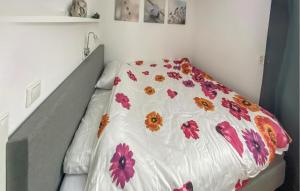 Una cama con un edredón blanco con flores. en Cozy Home In Eext With Kitchen, en Eext