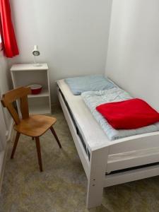 ハイリゲンハーフェンにあるFerienwohnung Spatzennestの小さなベッドルーム(ベッド1台、椅子付)