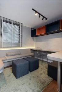 a living room with a bench and a table and stool at Apartamento Duplo Luxo com Jacuzi 6 lugares in Itajaí
