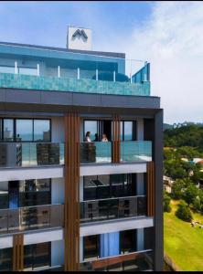 a building with a balcony with people on it at Apartamento Duplo Luxo com Jacuzi 6 lugares in Itajaí