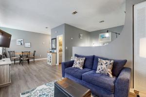 a living room with a blue couch and a table at Okaloosa Island Studio in Fort Walton Beach