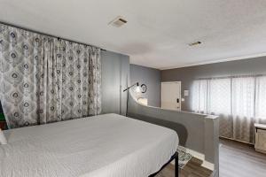 a bedroom with a white bed and a window at Okaloosa Island Studio in Fort Walton Beach