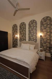 デヘラードゥーンにあるSpacious Colonial 4BHK; Green Lawn;Outdoor Jacuzziのベッドルーム1室(大きな白いベッド1台、一部の窓付)
