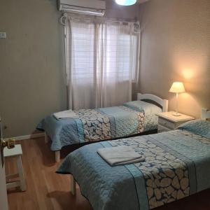 a room with two beds and a window at Libertador Hotel in La Rioja