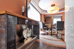 a room with a fireplace and a table with chairs at Grütter Luxury Apartments in Ischgl