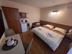 een kleine kamer met een bed en een tafel bij Apartmány Teddy Bojnice in Bojnice