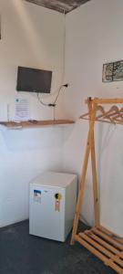 ブジオスにあるPousada Mare Blueの白い冷蔵庫と木製の棚が備わる客室です。