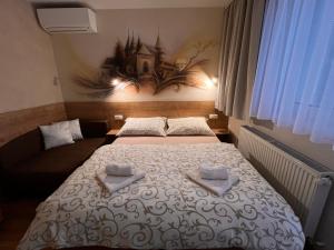 ein Schlafzimmer mit einem Bett mit zwei Handtüchern darauf in der Unterkunft Apartmány Teddy Bojnice in Bojnice
