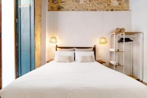 um quarto com uma grande cama branca e 2 almofadas em Apto López - Casa San Marcial em Las Palmas de Gran Canaria