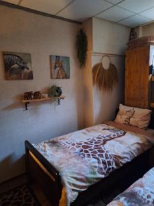 a bedroom with a bed with a giraffe blanket at B&B de Vrijheid en de Ruimte in Steenbergen in Steenbergen