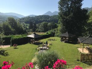 a garden with tables and chairs and mountains in the background at Au Songe du Valier- Chalets in Seix