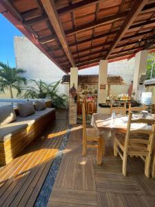 a wooden deck with a table and a couch at Casa com Piscina in Canavieiras