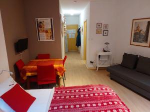 ein Wohnzimmer mit einem Bett, einem Sofa und einem Tisch in der Unterkunft Le BUBELE au coeur du centre médiéval et vignoble in Ribeauvillé