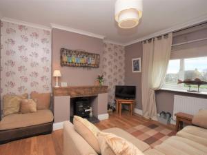 a living room with a couch and a fireplace at 3 Bed in Amble CN137 in Amble