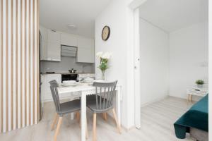 a kitchen and dining room with a table and chairs at Elegant Apartment in the centre of Gdynia by Renters in Gdynia