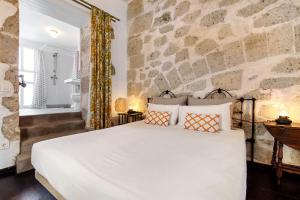 a bedroom with a large white bed and a stone wall at Apto Tatiana - Casa San Marcial in Las Palmas de Gran Canaria