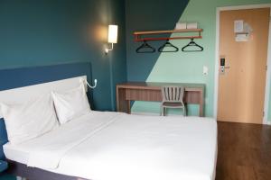 ein Schlafzimmer mit einem Bett, einem Schreibtisch und einem Stuhl in der Unterkunft ibis budget Muriae in Muriaé + 78 Fotos