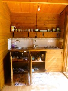 una cocina con fregadero en una cabaña de madera en Casita Louisa, en Chiclana de la Frontera