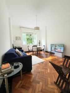 sala de estar con sofá azul y mesa en Apartamento 4 quartos 500m Arpoador, en Río de Janeiro