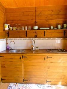 una cocina con armarios de madera y fregadero en Casita Louisa, en Chiclana de la Frontera