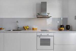 a white kitchen with white cabinets and a sink at Villa Tyra in Ražanj +58 photos