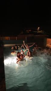 un grupo de personas en una piscina por la noche en Dodo House auberge de jeunesse, en Saint-Leu