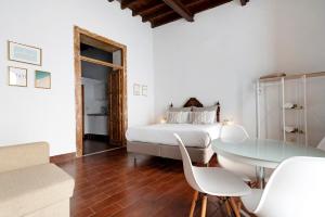 una camera bianca con un letto e un tavolo in vetro di Apto Don Pepe - Casa San Marcial a Las Palmas de Gran Canaria