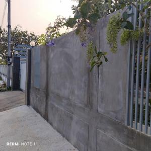 uma cerca de betão com uma planta em cima dela em Bann Sukjai em Kanchanaburi