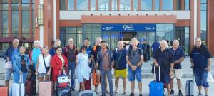 un grupo de personas de pie frente a un edificio con equipaje en Tony Central Hostel en Luang Prabang