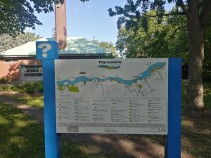 a sign in a park with a map at Comfortable 2-bedroom, private kitchen and bathroom in Montréal