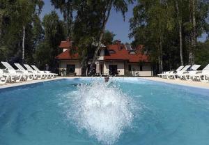 a swimming pool with a fountain in front of a house at Bajkowy Las in Mielno