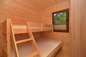 a wooden cabin with a bunk bed and a window at Bajkowy Las in Mielno
