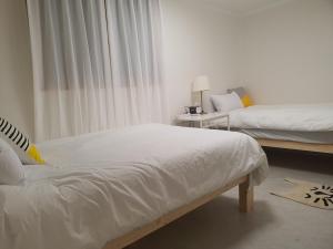 a bedroom with two beds with white sheets at Coco Stay in Seoul