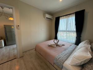 a bedroom with a bed with a bow on it at Plum Central Near shopping Mall @ Bangyai in Nonthaburi