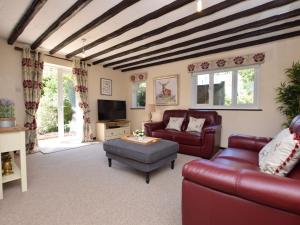 uma sala de estar com mobiliário de couro vermelho e uma televisão em 2 Bed in Lyndhurst 75879 em Totton