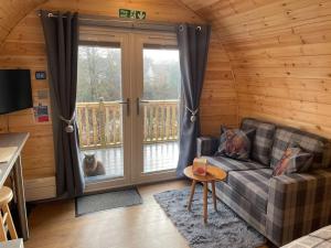 a living room with a couch and a window at Bonny Wee Snug - Pod in Spean Bridge in Spean Bridge