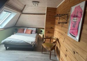 1 dormitorio con 1 cama y 1 silla en una habitación en 't Coureurke, en Brakel