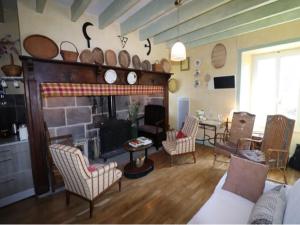 a living room with a fireplace with chairs and a table at Cottage in Auvergne near Puy Mary in LʼHôpital
