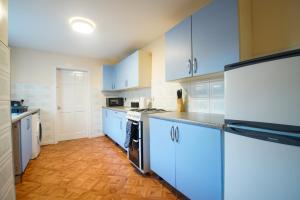 a kitchen with white cabinets and blue appliances at Comfy House for Contractors, Families, Accrington in Accrington