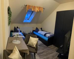 een kleine woonkamer met een bed en een tafel bij Pension Krahmer in Chemnitz