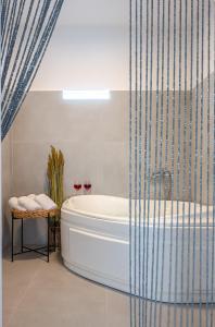 a bathroom with a tub and a shower at Noho Villas @ Sunlit house Paros in Nea Cryssi Akti